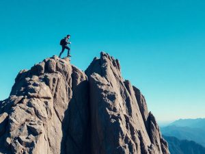 Persoană escaladând o stâncă în natură extremă.